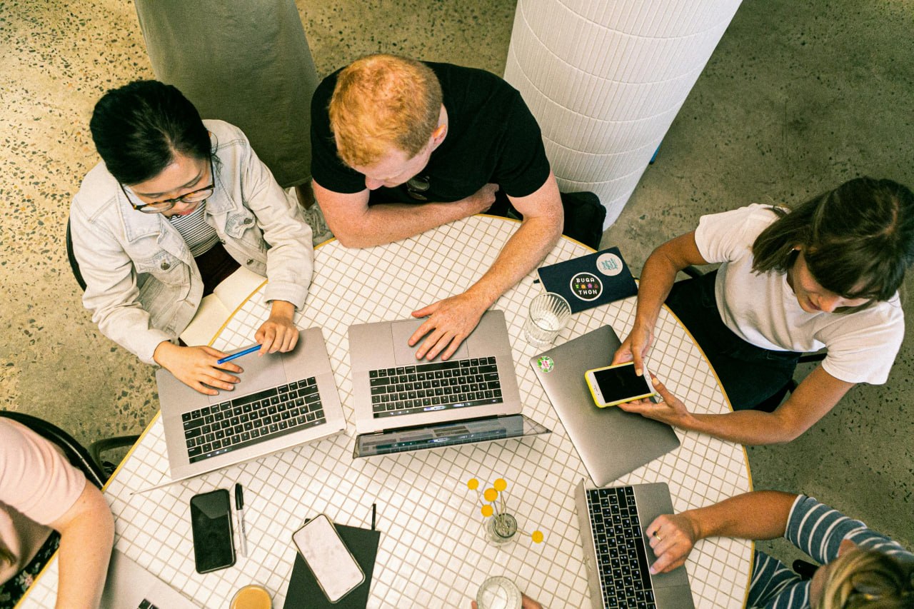 Really Easy Tech team collaborating around a table with laptops during a client workshop
